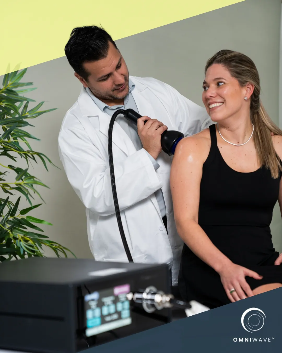 A doctor performing shockwave therapy on a woman's shoulder using a shockwave medical device.